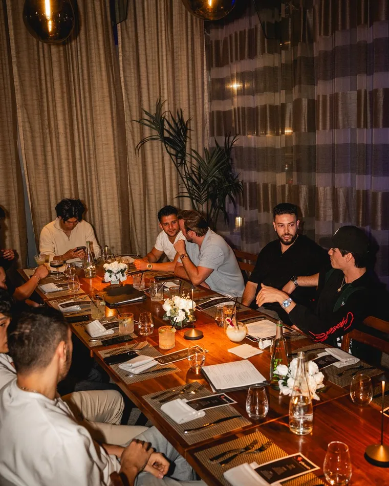 The Reign team around a long table at a private dinner