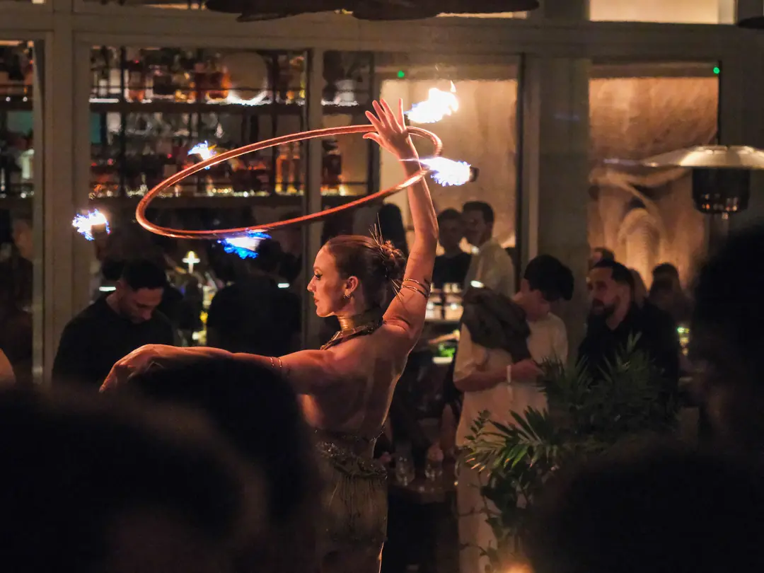 A fire performer spinning a flaming hoop for the crowd at a Reign event in Miami